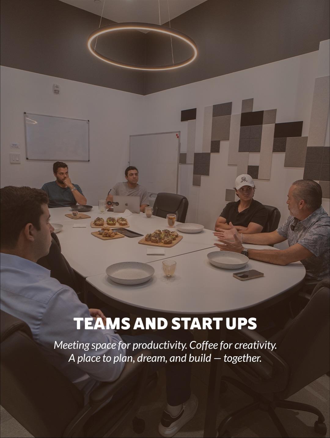 Team meeting around a table with food and drinks in a GROU Cowork meeting room, captioned Teams and Start Ups